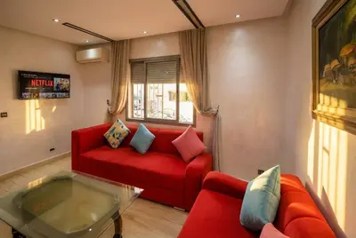 a living room with a red couch and a glass table at 1BR - Casa Voyageurs - Belvedere in Maarif