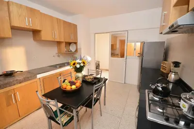 a kitchen with a table with a bowl of fruit on it at Abdelmoumen Central Spacious Haven in Maarif