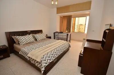 a bedroom with a large bed and a window at Abdelmoumen Central Spacious Haven in Maarif