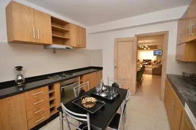 a kitchen with a table and chairs in a room at Abdelmoumen Central Spacious Haven in Maarif