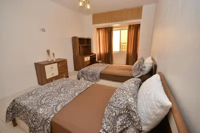 a hotel room with two beds and a television at Abdelmoumen Central Spacious Haven in Maarif