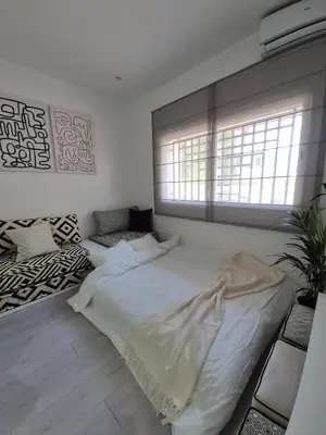 a bedroom with a large white bed and a window at Studio close to Descartes high school in Rabat