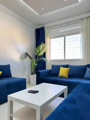 a living room with blue couches and a white table at SUITOUISS - Océan 2 - Panoramic Sea View in Downtown Rabat in Rabat