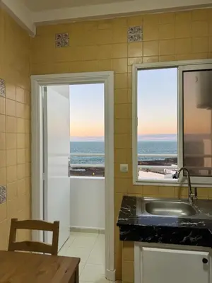 a kitchen with a sink and a view of the ocean at SUITOUISS - Océan 2 - Panoramic Sea View in Downtown Rabat in Rabat