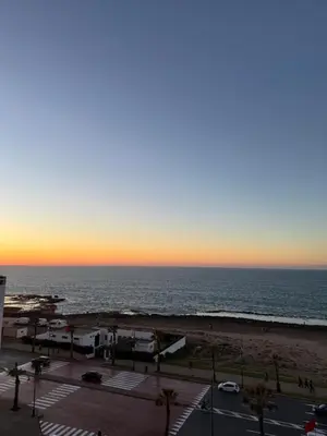 a view of the beach at sunset at SUITOUISS - Océan 2 - Panoramic Sea View in Downtown Rabat in Rabat