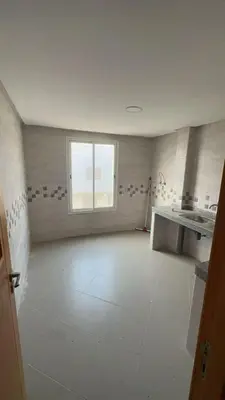 a large room with a white floor and a window at dekra bouznika in Bouznika