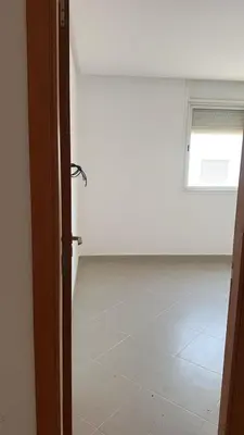 an open door to an empty room with a window at dekra bouznika in Bouznika