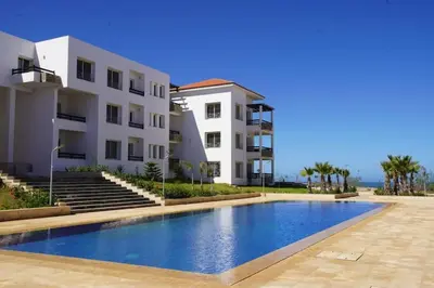 a swimming pool in front of a building at Apartment Ocean View in O Ben Slimane