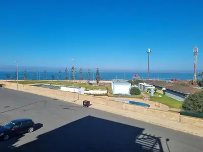 a parking lot with a car parked next to the ocean at Apartment Ocean View in O Ben Slimane