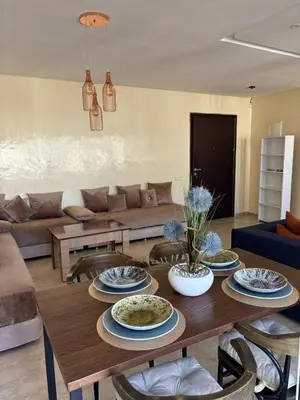 a living room with a table with plates on it at Apartment with pool view, 1 min to beach, private parking in Pont Blondin