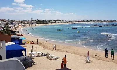 a group of people on a beach with the ocean at Apartment with pool view, 1 min to beach, private parking in Pont Blondin