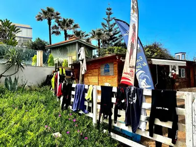 a fence with towels and snowboards on it at Apartment with pool view, 1 min to beach, private parking in Pont Blondin
