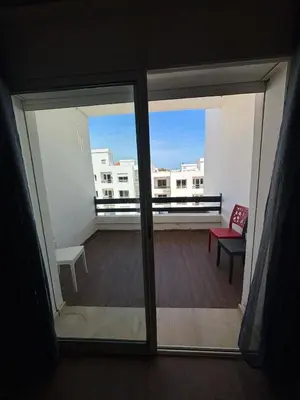 a view of a balcony from a room with a window at Apartment with pool view, 1 min to beach, private parking in Mansouria
