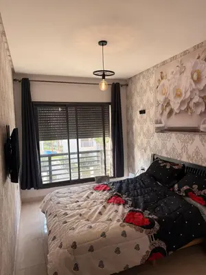 a bedroom with a bed and a large window at Cosy appart hotel Bouznika in O Ben Slimane