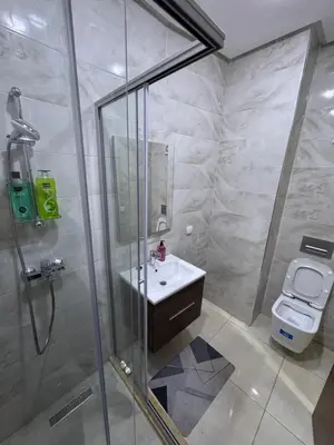 a bathroom with a shower and a sink and a toilet at Cosy appart hotel Bouznika in O Ben Slimane