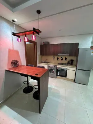 a kitchen with a wooden table and a stove at Cosy appart hotel Bouznika in O Ben Slimane