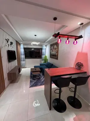 a living room with a table and a couch at Cosy appart hotel Bouznika in O Ben Slimane