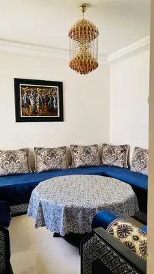 a living room with a table and a chandelier at Ola Blanca in Sidi Rahal