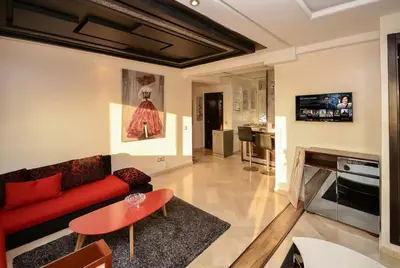 a living room with a red couch and a fireplace at Spacious City Bourgogne in Maarif
