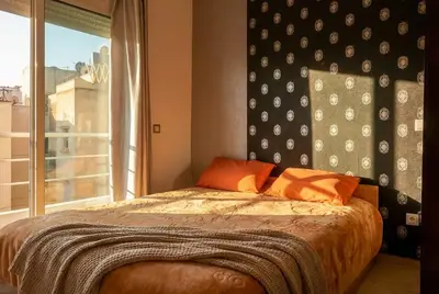 a bedroom with a bed with orange pillows and a window at Spacious City Bourgogne in Maarif
