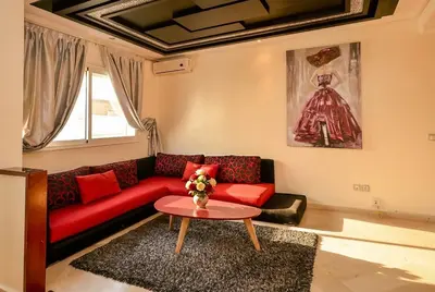 a living room with a red couch and a table at Spacious City Bourgogne in Maarif