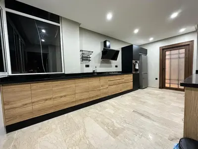 a large kitchen with wooden cabinets and a tv at 3 Rooms & View in Casablanca