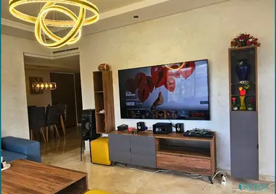 a living room with a large flat screen tv on a wall at Escapade océane à El Mansouria in Mansouria