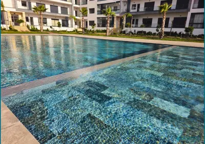 a large swimming pool in front of a building at Escapade océane à El Mansouria in Mansouria