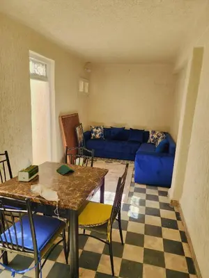 a living room with a blue couch and a table at Hachem in Rabat
