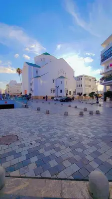 a large white building in a parking lot at Hachem in Rabat