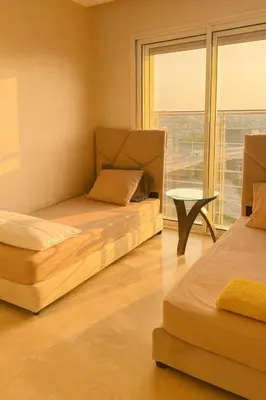 a room with two beds and a table and a window at Casablanca in panoramic mode in Casablanca