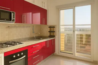 a kitchen with red cabinets and a microwave and a window at Casablanca in panoramic mode in Casablanca