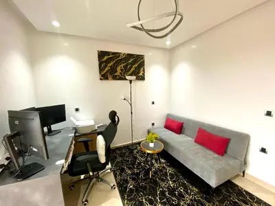 a living room with a couch and a desk with a computer at Stunning Views & Prime Location! in Casablanca