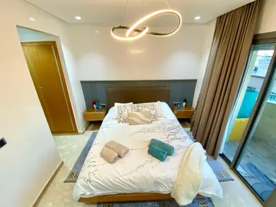a bedroom with a bed with white sheets and pillows at Stunning Views & Prime Location! in Casablanca