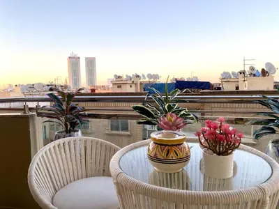 a table with two chairs and a vase with flowers on a balcony at Stunning Views & Prime Location! in Casablanca
