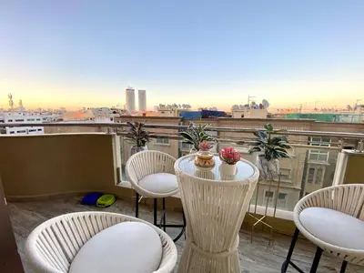 a balcony with a table and chairs and a view of a city at Stunning Views & Prime Location! in Casablanca