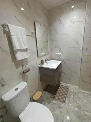 a white bathroom with a toilet and a sink at Appartement Golden Beach-Dahomey in Bouznika