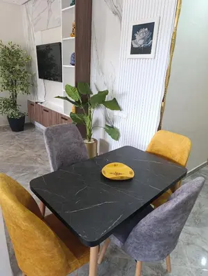 a black table with chairs and a yellow object on it at Appartement Golden Beach-Dahomey in Bouznika