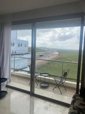 a room with a large window with chairs and a view at Charmant appartement à Anfa in Casablanca