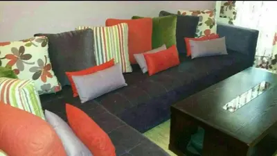 a black couch with colorful pillows and a coffee table at Home Stay Casa in Casablanca