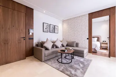 a living room with a couch and a table at Design 1BR Living Home M5 Stadium Balcony & Private Parking in Maarif