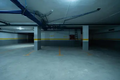 an empty parking garage with yellow and blue columns at Design 1BR Living Home M5 Stadium Balcony & Private Parking in Maarif