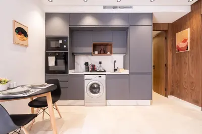 a kitchen with a washer and dryer next to a table at Design 1BR Living Home M5 Stadium Balcony & Private Parking in Maarif