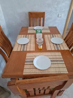 a wooden table with white plates on it at Appartement vue panoramique in Bouznika