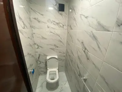 a white tiled bathroom with a toilet in it at casablanca,bourgogne,corniche in Casablanca