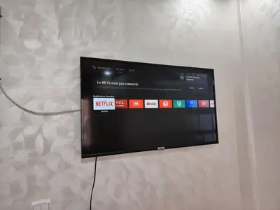 a flat screen tv hanging on a wall at Aeroport Tissir Appartement in Nouaceur