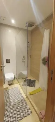 a bathroom with a glass shower and a toilet at Residence paradise beach el Mansoria in Mohammedia