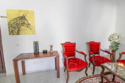 a room with red chairs and a table and a painting at Studio Panoramique, Mosquée Hassan II, Cœur de la Médina in Casablanca