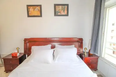 a bed with a wooden headboard and two pictures on the wall at Studio Panoramique, Mosquée Hassan II, Cœur de la Médina in Casablanca