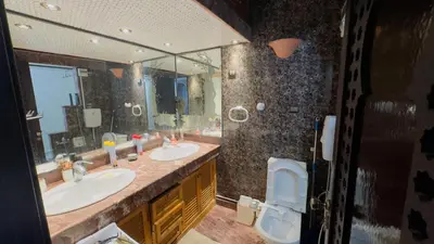 a bathroom with two sinks and a toilet and a mirror at Zaouia in Rabat